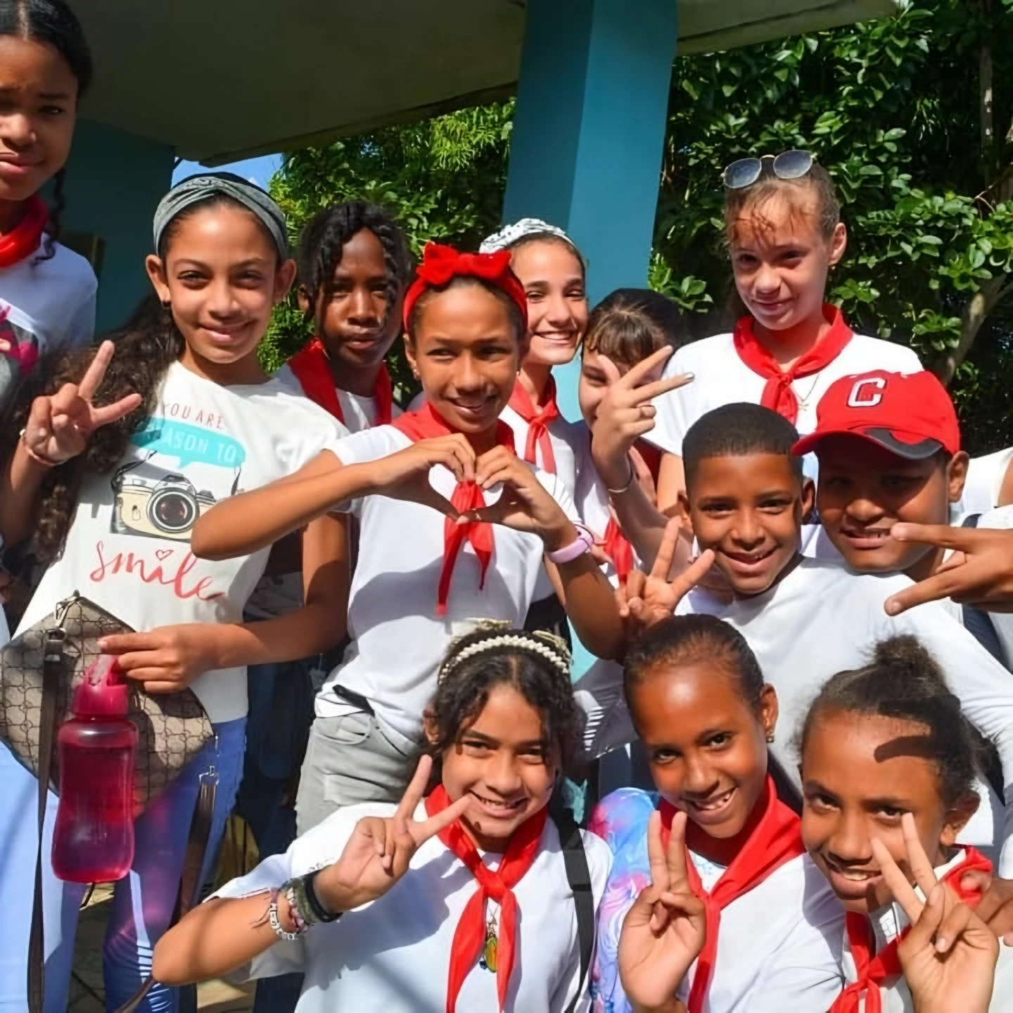 Group of smiling children and teenagers posing together outdoors